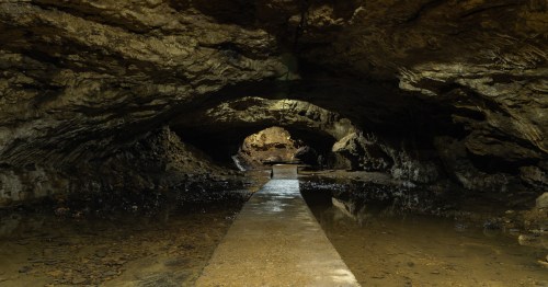A paved trail leads through an underground cave.