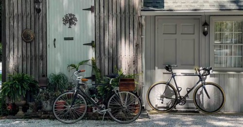 Exterior of the converted corn crib guesthouse with rustic wood siding and two bicycles parked outside.