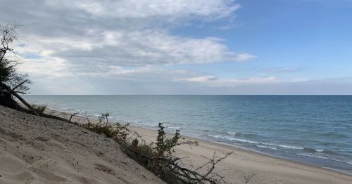 A sandy cliff overlooking a blue lake.