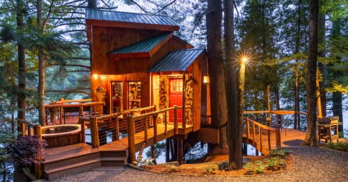 A nighttime view of the illuminated Vermont Tree Cabin Airbnb property in Newport, Vermont.