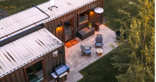 An aerial view of the exterior of a shipping container turned short-term rental with an outdoor patio area.