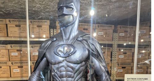 A display case with a Batman costume in it.