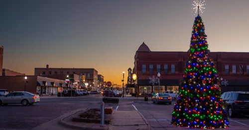 Downtown North Platte street at sunset, featuring a vibrant Christmas tree.