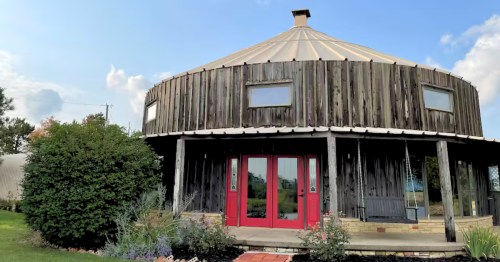 Grain bins turned into a vacation rental with wood siding and a big red door
