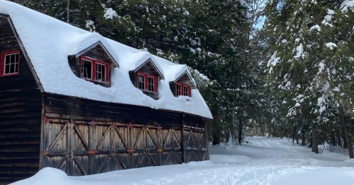 Snowy barn with red dormers along the Lowell Lake Trail in winter.