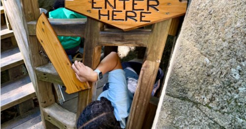 A girl squeezes her way through the Squeezer Gauge at the Lost River Gorge & Boulder Caves in North Woodstock, NH.