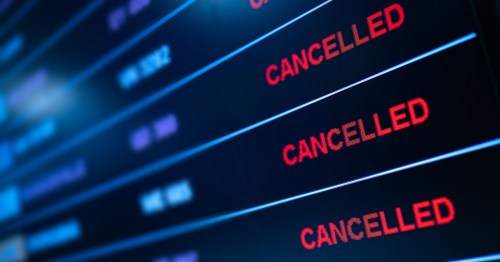 A flight departure board showing all flights cancelled.