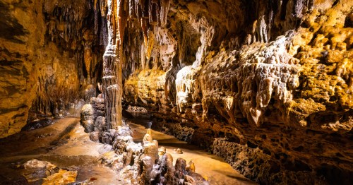 Shiny, tan rock formations inside of Cave of the Mounds