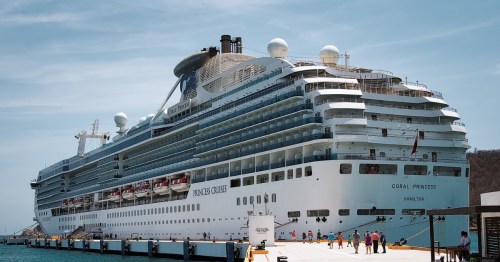 Princess Cruises ship Coral Princess docked in a tropical port.