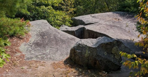 A large chasm opens up on top of a boulder at Dinosaur Caves