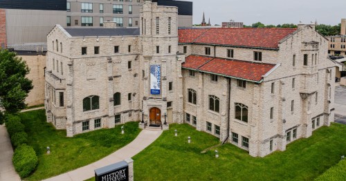 Front view of the stone History Museum at the Castle with bright green grass in front of it.