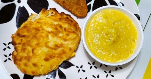 A plate with a large biscuit sandwich and a side of cheese grits at Angie’s Place, a mom-and-pop restaurant in Georgia.