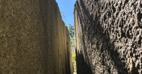 view of two tall rock walls with a narrow passage between them at purgatory chasm