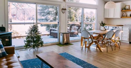 The interior of a cabin's living room space with large windows.