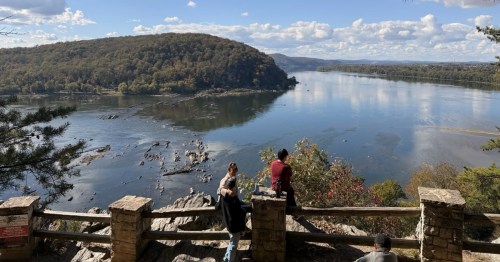 View of the Susquehanna River from Chickies Rock Overlook Trail, with people by a stone railing.