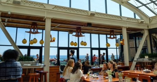 The interior of a rooftop restaurant with people dining.