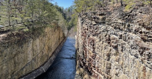 A narrow water channel is cut between towering, stratified rock walls at Rocky Gap State Park.