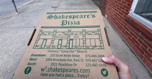 A hand holding a pizza box.