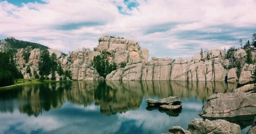 A lake reflecting large rocks off its surface.
