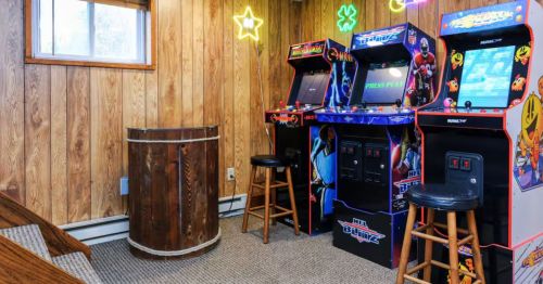 Three gaming consoles in a basement.