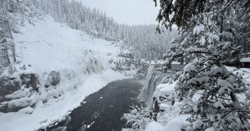A snow-covered forest surrounds a large waterfall in southeastern Idaho.
