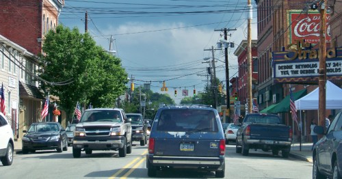 A view looking down Main Street in Zelienople, PA, with historic brick buildings and the prominent Strand Theater sign.
