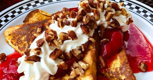 A checkered plate with French Toast covered in fruit and whipped cream, served at a retro-style diner in Georgia.
