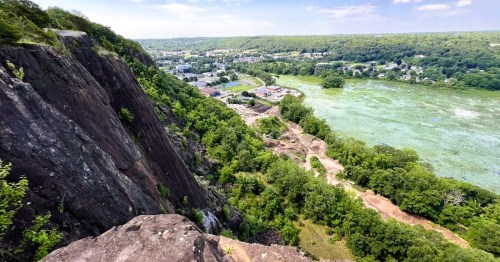 Views from a towering cliff of the city of New Haven, CT, surrounded by woodlands and water views in the distance.