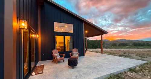 An outdoor lounge area on a patio outside of a cabin.