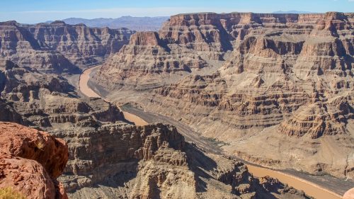 Panoramic view of the Grand Canyon in Arizona, with the Colorado River winding through rocky cliffs.