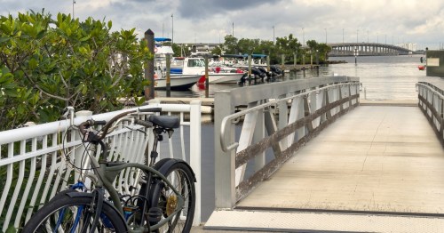 a bike is left against a fence by a marina dock in punta gorda florida