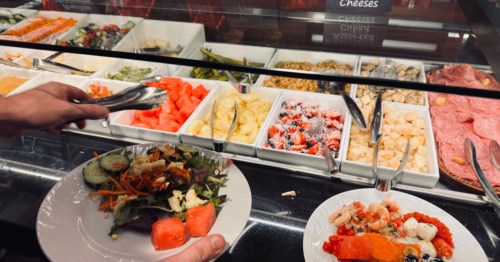 a buffet featurung fresh fruit with two filled plates at rodizio grill in scottsdale arizona