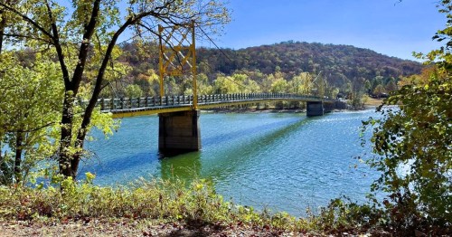 The Beaver Bridge in Beaver, Arkansas, along a scenic lake surrounded by a heavily wooded area.