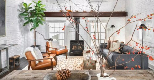 Bright, historic loft living space with original beams and a cozy wood-burning stove.