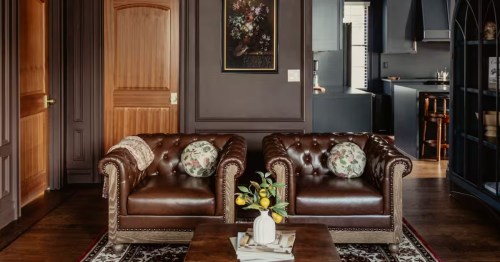 Upscale sitting area with leather club chairs and dark "Polo" aesthetic in a Providence rental.