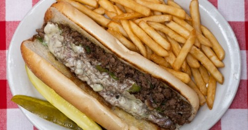 A Philly cheesesteak with shaved black Angus sirloin steak served on a 9-inch toasted hoagie roll with sauteed red onions and green bell peppers, and melted Swiss cheese
