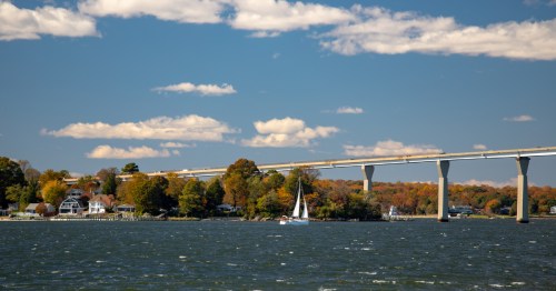 A sail boat glides across the sparkling waters of Solomon's Island in Maryland.