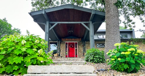 A stone hotel entrance with a red door and a wood awning in the Flint Hills, Kansas.