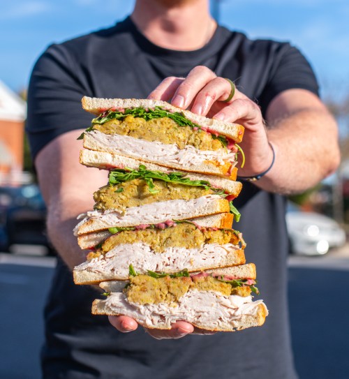 Person holding stacked sandwiches