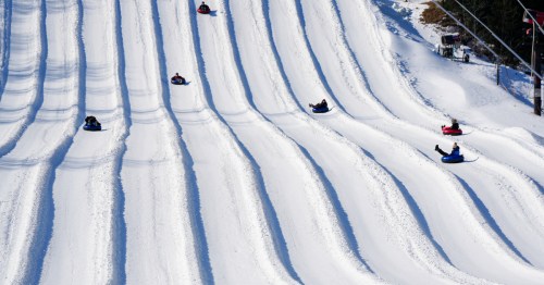 Several snow tubers glide down individual tube lanes at the Roundtop Mountain Resort in Lewisberry, Pennsylvania.