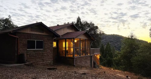 The exterior of the Sandstone Cottage Airbnb near Yosemite National Park at dusk.