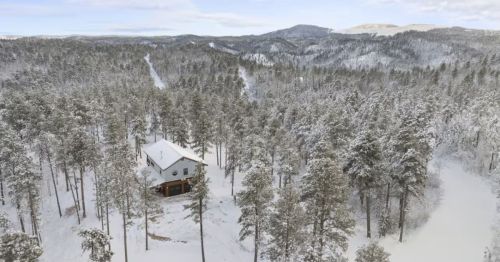 A cabin in a winter forest scene.