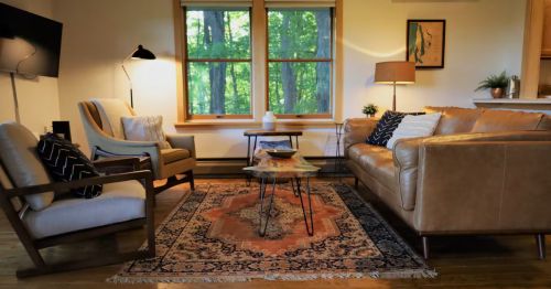 A living room with a couch and two chairs.