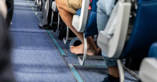 A passenger on a plane without shoes.