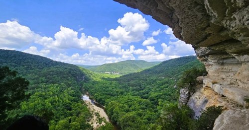 A bird's eye view of the Buffalo National River and the lush Ozark forest from a ledge along a massive bluff in Arkansas.