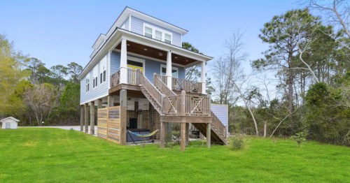 Exterior of a cozy Airbnb in Mississippi with a back deck and a hot tub