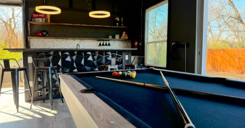 interior of a game room with a bar and pool table at an airbnb near the at&t stadium in arlington texas