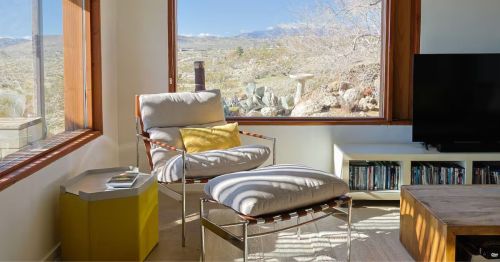 A living room with large windows overlooking the desert.