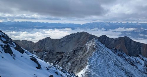 Rugged mountains are lightly dusted with snow and visible from the Mount Borah Trail in Idaho.