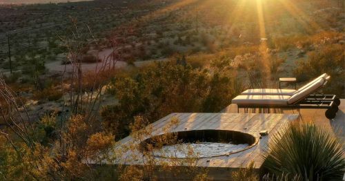An outdoor hot tub and deck at sunset.